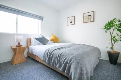 a bedroom with a bed and a potted plant at \u3077\u3075\u304b\u6771\u99d2\u5f62 in Tokyo
