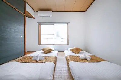 two beds in a room with a window at \u3077\u3075\u304b\u6771\u99d2\u5f62 in Tokyo