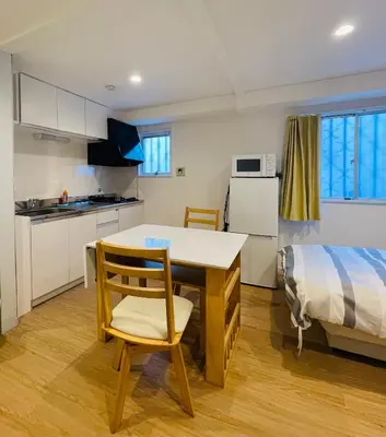 a kitchen with a table and chairs and a bed at Home SHINJUKU west 101 in Tokyo