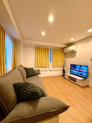 a living room with a couch and a flat screen tv at Home SHINJUKU west 101 in Tokyo