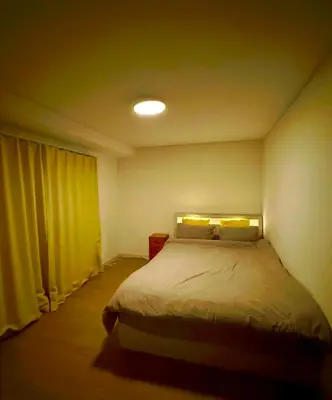 a bedroom with a bed with yellow curtains at Home SHINJUKU west 101 in Tokyo