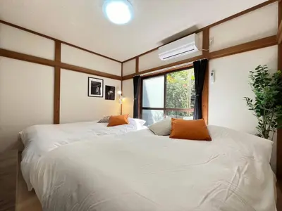 two beds in a room with a window at Mikazuki Akabane/MA1 in Tokyo