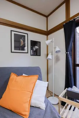 a living room with a blue couch with an orange pillow at Mikazuki Akabane/MA1 in Tokyo