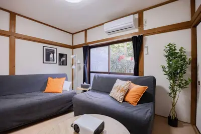 a living room with two blue couches and a window at Mikazuki Akabane/MA1 in Tokyo