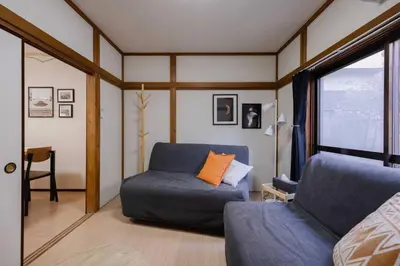 a room with a bed and a couch and a window at Mikazuki Akabane/MA1 in Tokyo
