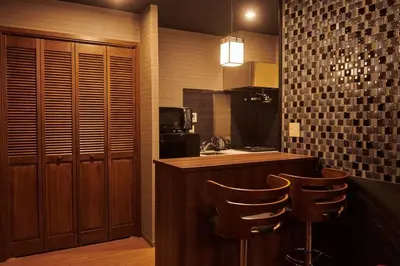 a kitchen with a counter and two bar stools at \u7d44\u7d10\u306e\u9593 in Tokyo