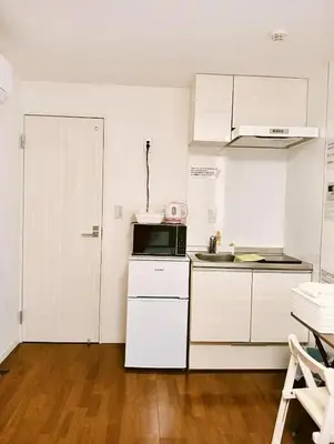 a kitchen with white cabinets and a microwave at KIYO Skytree Hotel \u9326\u7cf8\u753a\u99c5\u5f92\u6b69\uff13\u5206 in Tokyo