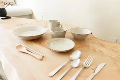 a wooden table with bowls and utensils on it at Saku House Jujo in Tokyo