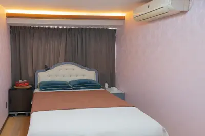 a bedroom with a white bed with blue pillows at AKARENGA house in Tokyo