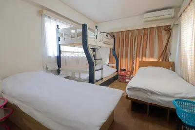 a bedroom with two beds and a bunk bed at AKARENGA house in Tokyo
