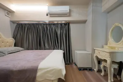a bedroom with a bed and a dresser and a mirror at AKARENGA house in Tokyo