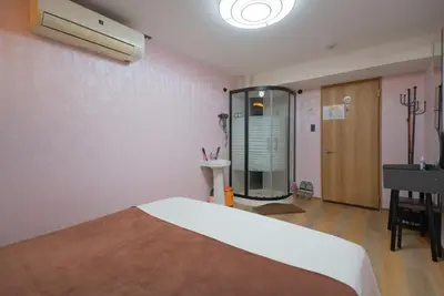 a room with a bed and a mirror and a sink at AKARENGA house in Tokyo