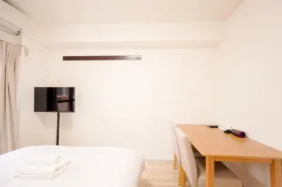 a bedroom with a table and a bed and a desk at Shinjuku Waseda Earthtone Apartment in Tokyo