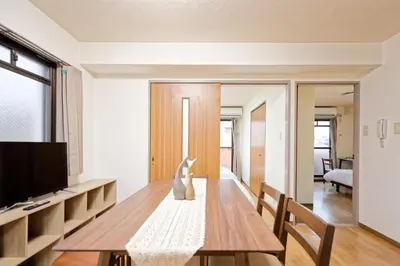 a living room with a wooden table and a television at Shinjuku Waseda Earthtone Apartment in Tokyo