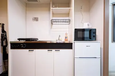 a kitchen with a sink and a microwave at Shinjuku Waseda Earthtone Apartment in Tokyo