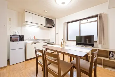 a kitchen with a table and chairs in a room at Shinjuku Waseda Earthtone Apartment in Tokyo