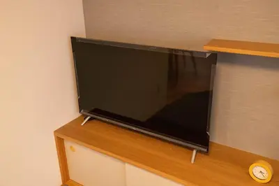 a flat screen tv sitting on top of a cabinet at \u6d45\u8349\u7985\u5fc3\u5c45202\u5ba4 \u6d45\u8349\u99c5\u5f92\u6b6915\u5206 2024\u5e744\u6708\u30cb\u30e5\u30fc\u30aa\u30fc\u30d7\u30f3 43\u5e73\u7c73\u4e38\u8cb8\u3057\u5207\u308a \u30c0\u30d6\u30eb\u30d9\u30c3\u30c82\u53f0\u3068\u7573\u6577\u304d\u5e03\u56e32\u7d44 \u5bb6\u5ead\u5f0f\u7528\u54c1\u8a2d\u5099\u5b8c\u5099 in Tokyo
