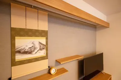 a room with a wall with a picture and a tv at \u6d45\u8349\u7985\u5fc3\u5c45301\u5ba4 \u6d45\u8349\u99c5\u5f92\u6b6915\u5206 2024\u5e744\u6708\u30cb\u30e5\u30fc\u30aa\u30fc\u30d7\u30f3 43\u5e73\u7c73\u4e38\u8cb8\u3057\u5207\u308a \u30c0\u30d6\u30eb\u30d9\u30c3\u30c82\u53f0\u3068\u7573\u6577\u304d\u5e03\u56e32\u7d44 \u5bb6\u5ead\u5f0f\u7528\u54c1\u8a2d\u5099\u5b8c\u5099 in Tokyo