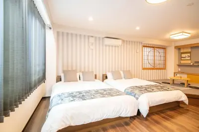 two beds are in a room with a piano at \u6d45\u8349\u7985\u5fc3\u5c45301\u5ba4 \u6d45\u8349\u99c5\u5f92\u6b6915\u5206 2024\u5e744\u6708\u30cb\u30e5\u30fc\u30aa\u30fc\u30d7\u30f3 43\u5e73\u7c73\u4e38\u8cb8\u3057\u5207\u308a \u30c0\u30d6\u30eb\u30d9\u30c3\u30c82\u53f0\u3068\u7573\u6577\u304d\u5e03\u56e32\u7d44 \u5bb6\u5ead\u5f0f\u7528\u54c1\u8a2d\u5099\u5b8c\u5099 in Tokyo
