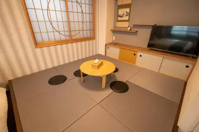 a living room with a table and a television at \u6d45\u8349\u7985\u5fc3\u5c45301\u5ba4 \u6d45\u8349\u99c5\u5f92\u6b6915\u5206 2024\u5e744\u6708\u30cb\u30e5\u30fc\u30aa\u30fc\u30d7\u30f3 43\u5e73\u7c73\u4e38\u8cb8\u3057\u5207\u308a \u30c0\u30d6\u30eb\u30d9\u30c3\u30c82\u53f0\u3068\u7573\u6577\u304d\u5e03\u56e32\u7d44 \u5bb6\u5ead\u5f0f\u7528\u54c1\u8a2d\u5099\u5b8c\u5099 in Tokyo