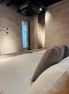 a bedroom with two white beds and a blue door at IKEBUKURO TOKIWA 10 BUILDING 6min walk from Ikebukuro Station Direct access to the airport in Tokyo