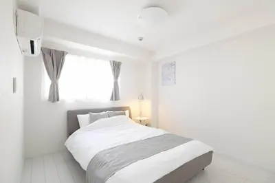 a white bedroom with a bed and a window at \u30aa\u30fc\u30b7\u30e3\u30f3\u30ba\u30b9\u30a4\u30fc\u30c8 \u6771\u4eac\u30c7\u30a3\u30ba\u30cb\u30fc\u30ea\u30be\u30fc\u30c8\u30b3\u30fc\u30b8\u30fc\u30d0\u30eb\u30b3\u30cb\u30fc302 in Tokyo