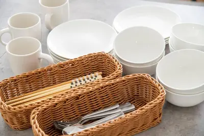 a basket with utensils on a table with cups and plates at \u30aa\u30fc\u30b7\u30e3\u30f3\u30ba\u30b9\u30a4\u30fc\u30c8 \u6771\u4eac\u30c7\u30a3\u30ba\u30cb\u30fc\u30ea\u30be\u30fc\u30c8\u30b3\u30fc\u30b8\u30fc\u30d0\u30eb\u30b3\u30cb\u30fc302 in Tokyo