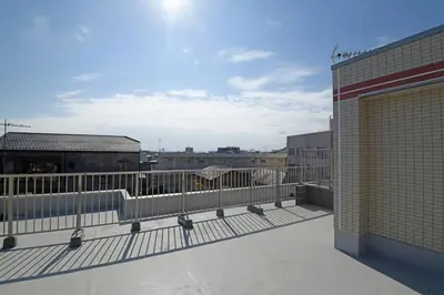 a balcony of a building with a fence and buildings at \u30aa\u30fc\u30b7\u30e3\u30f3\u30ba\u30b9\u30a4\u30fc\u30c8 \u6771\u4eac\u30c7\u30a3\u30ba\u30cb\u30fc\u30ea\u30be\u30fc\u30c8\u30b3\u30fc\u30b8\u30fc\u30d0\u30eb\u30b3\u30cb\u30fc302 in Tokyo