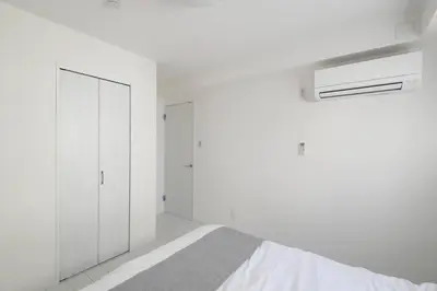 a white bedroom with a bed and a closet at \u30aa\u30fc\u30b7\u30e3\u30f3\u30ba\u30b9\u30a4\u30fc\u30c8 \u6771\u4eac\u30c7\u30a3\u30ba\u30cb\u30fc\u30ea\u30be\u30fc\u30c8\u30b3\u30fc\u30b8\u30fc\u30d0\u30eb\u30b3\u30cb\u30fc302 in Tokyo