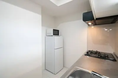 a kitchen with a white refrigerator and a sink at \u30aa\u30fc\u30b7\u30e3\u30f3\u30ba\u30b9\u30a4\u30fc\u30c8 \u6771\u4eac\u30c7\u30a3\u30ba\u30cb\u30fc\u30ea\u30be\u30fc\u30c8\u30de\u30ea\u30f3\u30d0\u30eb\u30b3\u30cb\u30fc303\u5ba4 in Tokyo