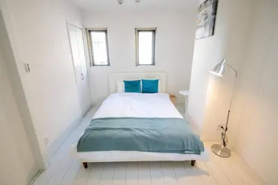 a bedroom with a large bed with blue pillows at \u30aa\u30fc\u30b7\u30e3\u30f3\u30ba\u30b9\u30a4\u30fc\u30c8 \u6771\u4eac\u30c7\u30a3\u30ba\u30cb\u30fc\u30ea\u30be\u30fc\u30c8\u30de\u30ea\u30f3\u30d0\u30eb\u30b3\u30cb\u30fc303\u5ba4 in Tokyo