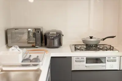 a kitchen counter with a stove and a microwave at Tokyo Kitaku hotel in Tokyo