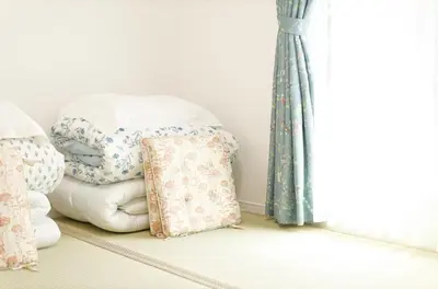 a room with a pile of blankets and a window at Tokyo Kitaku hotel in Tokyo