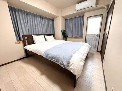a bedroom with a large bed and a window at Okubo Sta10min walk/ Shinjyuku Sta 2min/85 ㎡/3LDK in Tokyo