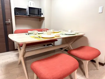 a dining room table with two red chairs and a table at Okubo Sta10min walk/ Shinjyuku Sta 2min/85 ㎡/3LDK in Tokyo