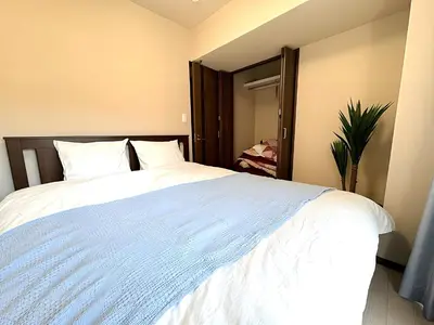 a bedroom with a large bed with white sheets at Okubo Sta10min walk/ Shinjyuku Sta 2min/85 ㎡/3LDK in Tokyo