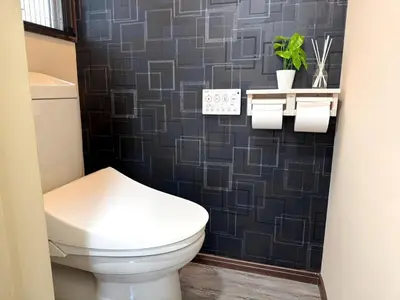 a bathroom with a toilet and a black tile wall at Okubo Sta10min walk/ Shinjyuku Sta 2min/85 ㎡/3LDK in Tokyo