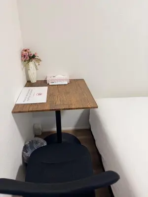 a desk in a corner with a chair and flowers at 2 bedrooms entire house in Tokyo