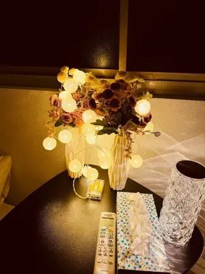 a table with a vase of flowers and a remote control at 2 bedrooms entire house in Tokyo
