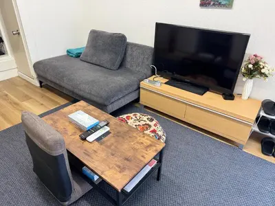 a living room with a couch and a television at 2 bedrooms entire house in Tokyo