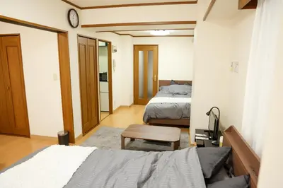 a small bedroom with two beds and a table at Toudaimae Mukougaoka Corpo #MTM in Tokyo