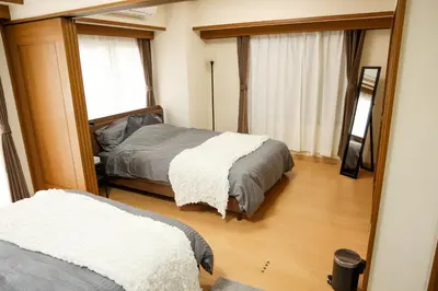 a bedroom with two beds and a mirror at Toudaimae Mukougaoka Corpo #MTM in Tokyo