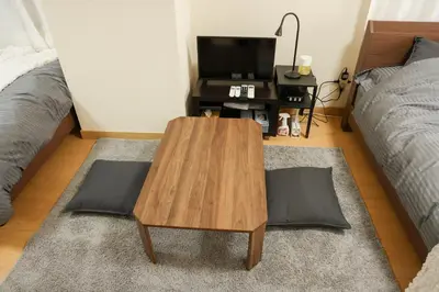 a living room with a wooden coffee table and a bed at Toudaimae Mukougaoka Corpo #MTM in Tokyo