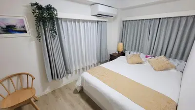 a bedroom with a bed and a chair and a window at miyabi I - \u96c5 I in Tokyo