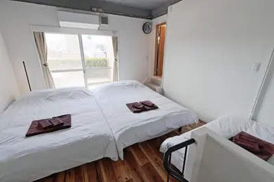 two beds in a small room with a window at V Close to Olympic Stadium Sendagaya Roof top Terrace in Tokyo