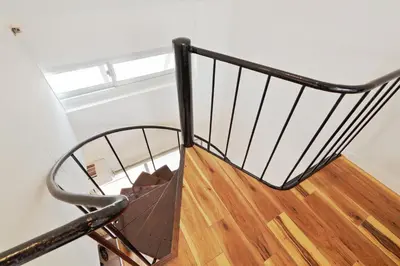 a winding staircase with a metal railing and wooden floors at V Close to Olympic Stadium Sendagaya Roof top Terrace in Tokyo
