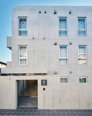 a building with a concrete facade with windows at da Haus Shinjuku in Tokyo