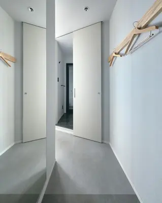 an empty hallway with white walls and a mirror at da Haus Shinjuku in Tokyo