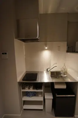 a small kitchen with a sink and a stove at da Haus Shinjuku in Tokyo