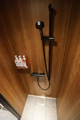 a wooden wall with a hose attached to a wall at da Haus Shinjuku in Tokyo
